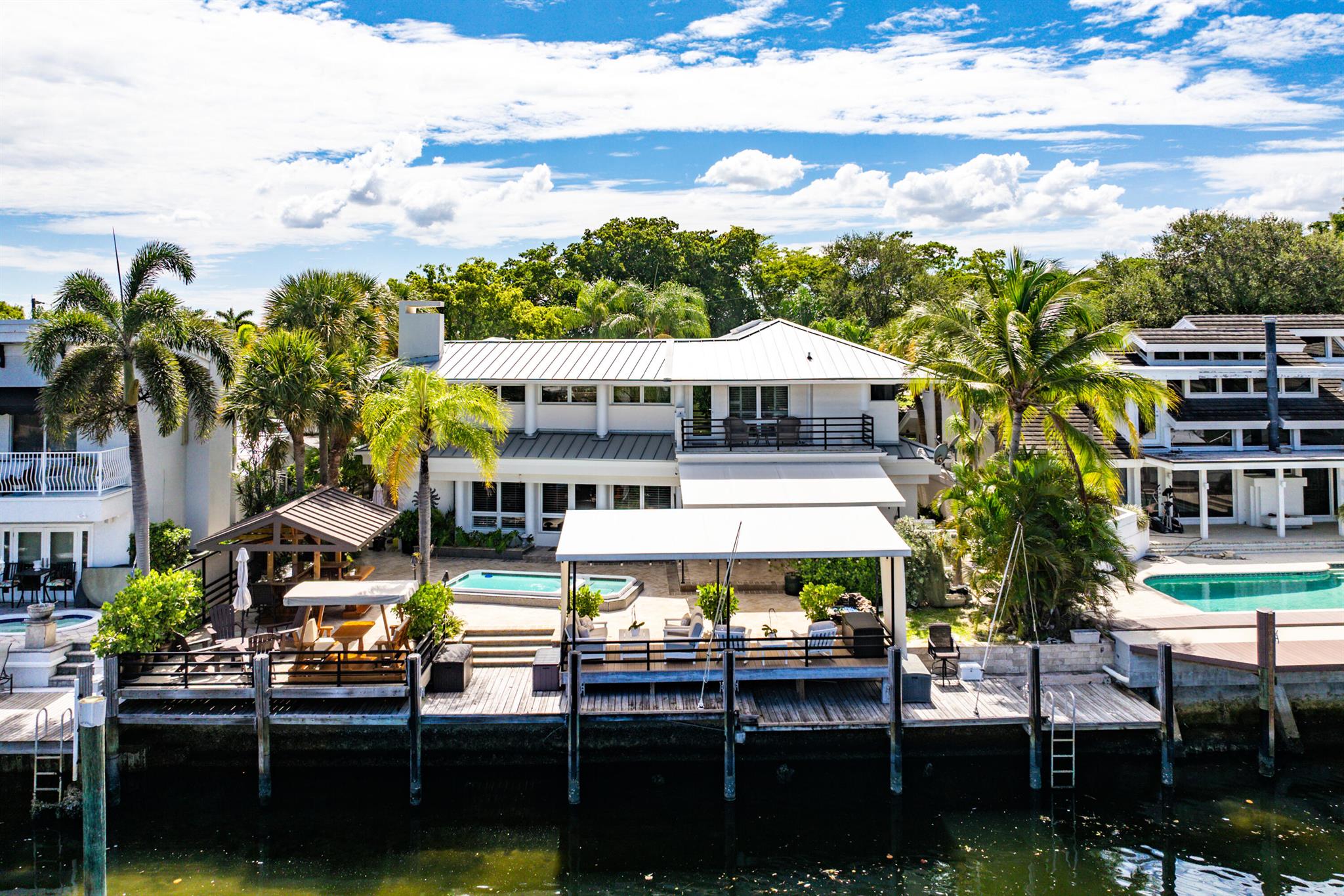 Experience elevated waterfront living in this exceptional Pompano Beach residence, boasting 70 ft of prime Intracoastal frontage with no fixed bridges. Enjoy a private dock, swim spa, hot tub, outdoor bar, and full-house generator. Inside, refined open-concept spaces feature 2 bedrooms, 4 full baths, and an upstairs loft with ensuite--perfect as a third bedroom or second primary. The elegant primary suite offers a flex room ideal for an office, gym, or nursery. Chef's kitchen, cabana bath, and sun-filled interiors add to the appeal. No HOA or rental restrictions. Minutes from top private schools: Pine Crest, Westminster, and St. Coleman's.