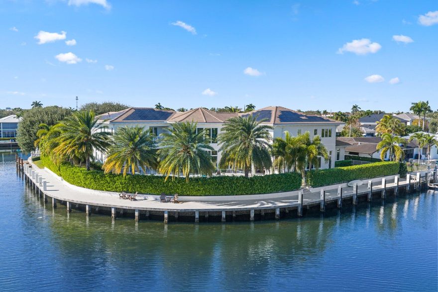 Located on a 240-foot southeast-facing waterfront point lot on the South Grand Canal, this Hamptons-inspired estate offers timeless design, modern technology, and exceptional indoor-outdoor living. Built in 2020 by Zahn Builders of Lighthouse Point, the home features refined millwork, coffered ceilings, soaring ceiling heights, and expansive windows that fill the interiors with natural light.



The grand foyer opens to formal living and dining spaces with a 500+ bottle refrigerated wine bar, ideal for entertaining. Walls of glass lead to a resort-style outdoor kitchen, private pool framed by lush hedging, orchid sanctuary, courtyard, and fenced areas perfect for pets and children.

The thoughtfully designed layout includes a first-floor secondary primary suite, private office, and two powder rooms. Upstairs are five en-suite bedrooms with walk-in closets, including a luxurious primary suite, plus an upstairs club room with bar, expansive loggia, oversized pantry, and three-car garage.



A fully integrated smart-home system features Lutron lighting and shades, enterprise-grade whole-home Wi-Fi, security cameras, smart locks, thermostats, and Apple HomeKit with Siri control. An architecturally integrated solar tile roof with a 22.5 kW system and three Tesla Powerwalls provides whole-home backup, off-grid capability, and netmetering for reduced utility costs.



A rare opportunity to own a technologically advanced waterfront estate on one of the largest single-family lots in Lighthouse Point.
