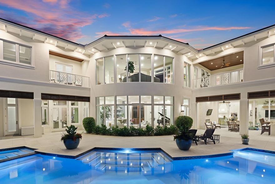 Located on a 240-foot southeast-facing waterfront point lot on the South Grand Canal, this Hamptons-inspired estate offers timeless design, modern technology, and exceptional indoor-outdoor living. Built in 2020 by Zahn Builders of Lighthouse Point, the home features refined millwork, coffered ceilings, soaring ceiling heights, and expansive windows that fill the interiors with natural light.



The grand foyer opens to formal living and dining spaces with a 500+ bottle refrigerated wine bar, ideal for entertaining. Walls of glass lead to a resort-style outdoor kitchen, private pool framed by lush hedging, orchid sanctuary, courtyard, and fenced areas perfect for pets and children.

The thoughtfully designed layout includes a first-floor secondary primary suite, private office, and two powder rooms. Upstairs are five en-suite bedrooms with walk-in closets, including a luxurious primary suite, plus an upstairs club room with bar, expansive loggia, oversized pantry, and three-car garage.



A fully integrated smart-home system features Lutron lighting and shades, enterprise-grade whole-home Wi-Fi, security cameras, smart locks, thermostats, and Apple HomeKit with Siri control. An architecturally integrated solar tile roof with a 22.5 kW system and three Tesla Powerwalls provides whole-home backup, off-grid capability, and netmetering for reduced utility costs.



A rare opportunity to own a technologically advanced waterfront estate on one of the largest single-family lots in Lighthouse Point.