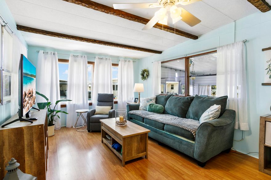 This charming 2 bed, 1 bath home sits in a desirable 55+ gated community offering abundant activities, including pickleball courts, shuffleboard, heated pools, bingo, cards, dances, potlucks, and game nights. Recently painted, it features laminate flooring, vaulted living‑room ceilings with decorative beams, newer windows, and a kitchen with ample counter space and a breakfast bar. Enjoy extra living space in the spacious Florida room. The second bedroom works well for guests or an office, and the main bedroom connects to a step‑in shower bath. A side‑entry ramp and storage shed with washer and dryer add convenience. Ideal for snowbirds, the home is easy to maintain and close to beaches, shopping, and dining.