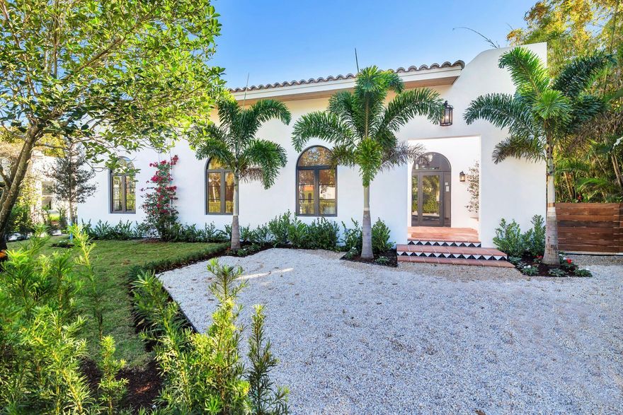 This reimagined Ranch-style residence (with Spanish flair) offers timeless design with contemporary finishes ideal for modern Florida living. Situated just two blocks from the Intracoastal, this concrete-built home is as durable as it is beautiful, featuring complete impact glass for ultimate peace of mind. Step inside from the entry courtyard to soaring vaulted ceilings and a chef's kitchen that will delight entertainers and culinary enthusiasts alike. Anchored by a large kitchen island, the space is outfitted with high-end appliances and thoughtfully designed for both functionality and style. The primary suite is a private retreat, boasting an expansive walk-in closet and a spa-like ensuite bathroom. Two additional bedrooms and an open floor plan with spacious living areas provide ample