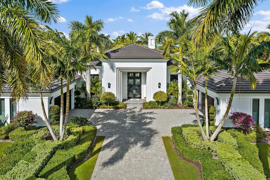 This Stunning Savoy Model home is situated on a very special private 1/2 acre lot in the sought after Grand Estate section of Old Palm Golf Club. Contemporary architecture designed by award winning Affiniti Architects and built by renowned Courchene Development with the finest appointments.  As you enter the 12 foot custom French foyer doors, you are drawn to the luxury mill work and ceiling treatments that lead you into the living room, featuring a beautiful Brazilian Sequoia marble surround linear fireplace and sweeping views of the lushly landscaped property with flowing palms, flowering trees and Bougainvillea.  The main living area displays white polished marble flooring with marble inlays throughout. The family room showcases an impressive, custom wine display and bar with modern