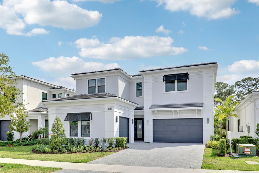 Experience luxury living in this exceptional Mondrian model in Artistry, offering more than 4,000 square feet of thoughtfully designed living space and high-end finishes throughout. The open floor plan features two elegant fireplaces and a first-floor owner's suite with a coffered ceiling, spa-inspired bath, oversized shower, soaking tub, and spacious walk-in closet. The gourmet kitchen is designed for both everyday living and entertaining, complete with GE Monogram appliances, a 42" built-in refrigerator, gas cooktop, double wall ovens, quartz countertops, wine fridge, and custom cabinetry. A dramatic wood staircase, abundant natural light, and a convenient first-floor laundry room further enhance the home's appeal.  Upstairs, an expansive loft and game space with an electric fireplace and wet bar creates the perfect gathering area, surrounded by three additional bedrooms, each with its own ensuite bath. Additional features include two air-conditioned garages accommodating 3 vehicles, electric roll-down screens on the back patio, a summer kitchen, and a fenced-in yard for added privacy. Overlooking a tranquil preserve, the backyard offers ample room for a custom pool and spa, making this home ideal for refined indoor-outdoor living.  Located in the gated community of Artistry, offering 24/7 armed security, clubhouse with fitness center and event space, resort-style pool, walking trails, playground, and sport courts. Prime location near I-95, Alton Town Center, The Gardens Mall, Life Time Fitness, pristine beaches, and just 20 minutes to PBI Airport.