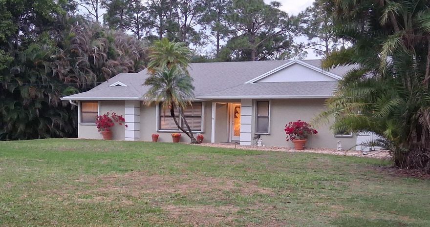 Rare Jupiter Farms opportunity on 1.09 acres! This 3BR/2BA home offers 1,835 sq ft under air w/ a split floor plan & walk-in closets in all bedrooms, plus multiple living areas including a spacious 25' x 17' den w/ fireplace, formal living & dining rooms. Enjoy Florida living in your screened-in pool & covered lanai, perfect for relaxing or entertaining year-round. Private, lush setting w/ room for boats, RVs, animals, hobby farm or workshop. Hurricane protection (storm shutters) & NO HOA—bring your toys! Major updates include A/C (2016), septic (2024), well shaft (2020) & water filtration (2020/2025). Experience true Florida country living w/ space, freedom & privacy, all just 15-20 min to Jupiter Beach, inlet, dining, shopping & I-95/Turnpike.