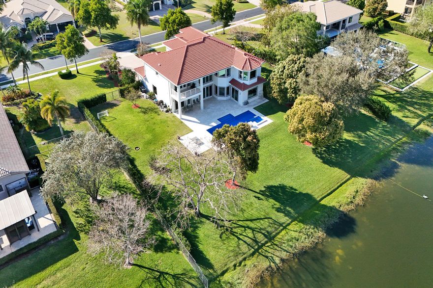 Experience true luxury living in this stunning 5 BR 6 BA estate on a massive (near 1 acre) lot complete with a brand new sparkling Van Kirk designed saltwater pool and spa, overlooking the lake. New roof, AC and impact windows! Towering floor to ceiling windows draw in an abundance of light to every room. Enjoy the spectacular water views from the moment you enter your home and its grand foyer. The large impressive living room w/ wet bar and the bright kitchen open up to your oasis backyard making this a true indoor-outdoor home, perfect for entertaining. Your immense backyard is surrounded by lush mature fruit trees adding to its tropical feel and lending much privacy. No detail has been spared. New gourmet kitchen with an oversized island & gorgeous marbled Brazilian stone countertops,  smart wi-fi appliances, a walk-in pantry, including the custom led lighting makes for a very light, open kitchen. This expanded Van Gogh model gives you the convenience of a bedroom on the main floor for guests or a live-in nanny. Main level also features a true dedicated substantial home office with large bookcases, plenty of shelving and room for two. Your private dining-room is stunning, with coffered ceilings, a picture window letting in lush, green garden views, while comfortably seating 12 for dinner parties. On the second story, enjoy a grand primary BR overlooking the water, his & her separate walk-in closets and a very large spa like bath with whirlpool jacuzzi tub. You have 3 additional bedrooms all with their own en-suite bath, a loft/media room which opens to an expansive covered balcony, overlooking your private backyard water oasis. Living here, you feel like you are on vacation every day! The epitome of Florida lifestyle! Ample consideration for cars here with 2 garages and an extended driveway to fit many more automobiles. Adding to convenience for electric vehicles you have not one but two EV stations. Utilizing modern technology this smart home offers Savant home automation system for integrating lighting, climate, entertainment, security and energy from one customizable interface. Long Lake Ranches is a coveted guard gated community known for its proximity to THE TOP-RATED SCHOOLS in the nation! Amenities include clubhouse, fitness center, tennis courts & basketball court. You are near equestrian trails & the scenic Tree Tops Park and minutes to great dining, restaurants and entertainment. This home provides the perfect mix of luxury, privacy and location.