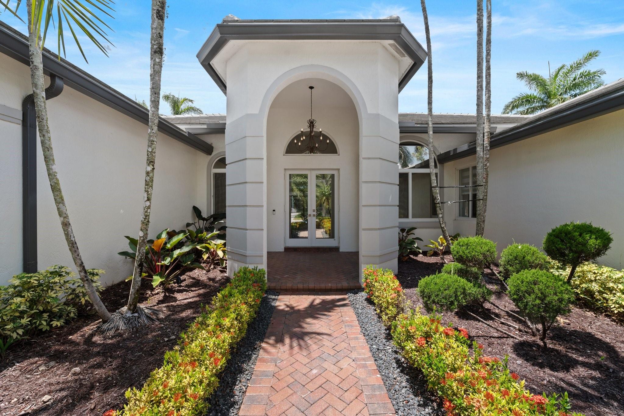 Stunning Luxury waterfront pool home in exclusive Weston Hills Country Club! This immaculate residence encompasses what a model home feels like featuring a **new roof**, full **impact glass**, and exquisite **high-end upgrades**. The gourmet kitchen & spa-like bathrooms are beautifully appointed with designer finishes. **Attention to detail** shines in every space. Home includes an additional **dedicated office** and a **sunroom** perfect as a playroom, den, or creative retreat. Enjoy tranquil water views and elegant outdoor living in this move-in ready masterpiece! Enjoy serene water views from the resort-style pool with raised spa, surrounded by natural stone deck. Take note of the custom doors throughout the residence that gives a grand feel along with barn door to the laundry room.