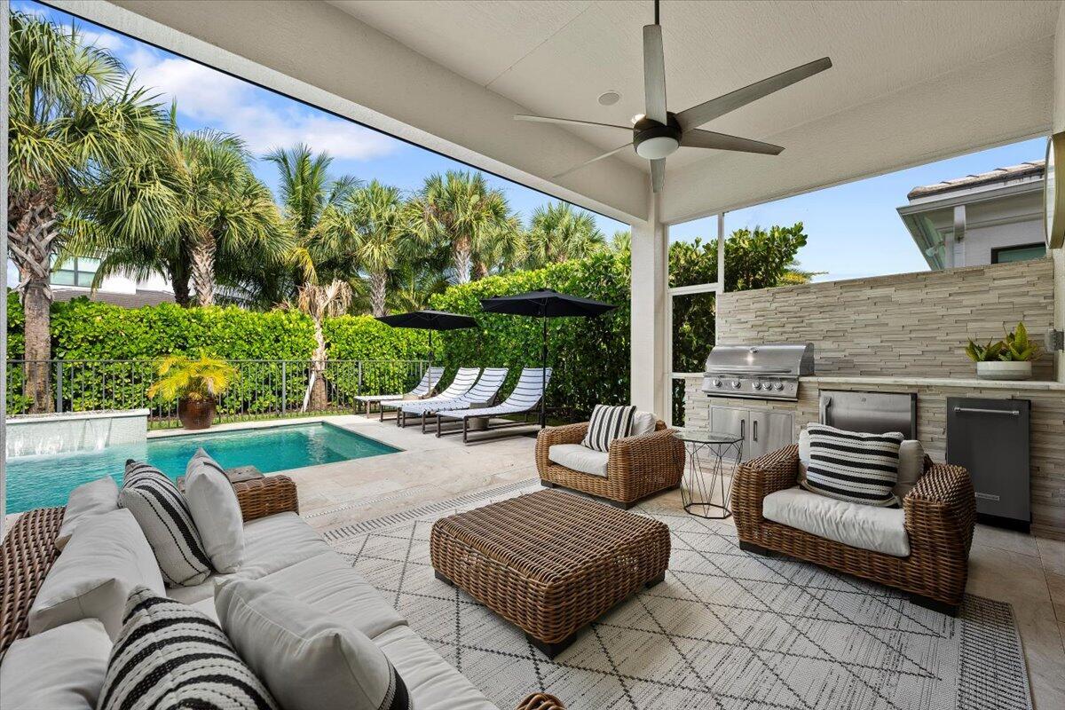 Highly upgraded single-story home in the prestigious gated community of Artistry! This stunning 3-bedroom, 3-bathroom home with a versatile den--perfect for a home office, playroom, or guest space. Thoughtfully designed with a spacious split floor plan, high ceilings, and elegant wood laminate flooring throughout, this home combines style and functionality. The gourmet kitchen features premium builder upgrades, custom cabinetry, and top-of-the-line appliances. Step outside to your private backyard oasis complete with a heated salt-water pool/hot tub and a summer kitchen featuring a beverage refrigerator, ice maker, and stainless-steel grill, ideal for relaxing or hosting guests. Plantation shutters throughout, built-in Sonos sound system, and Lutron motorized blinds are some of the many