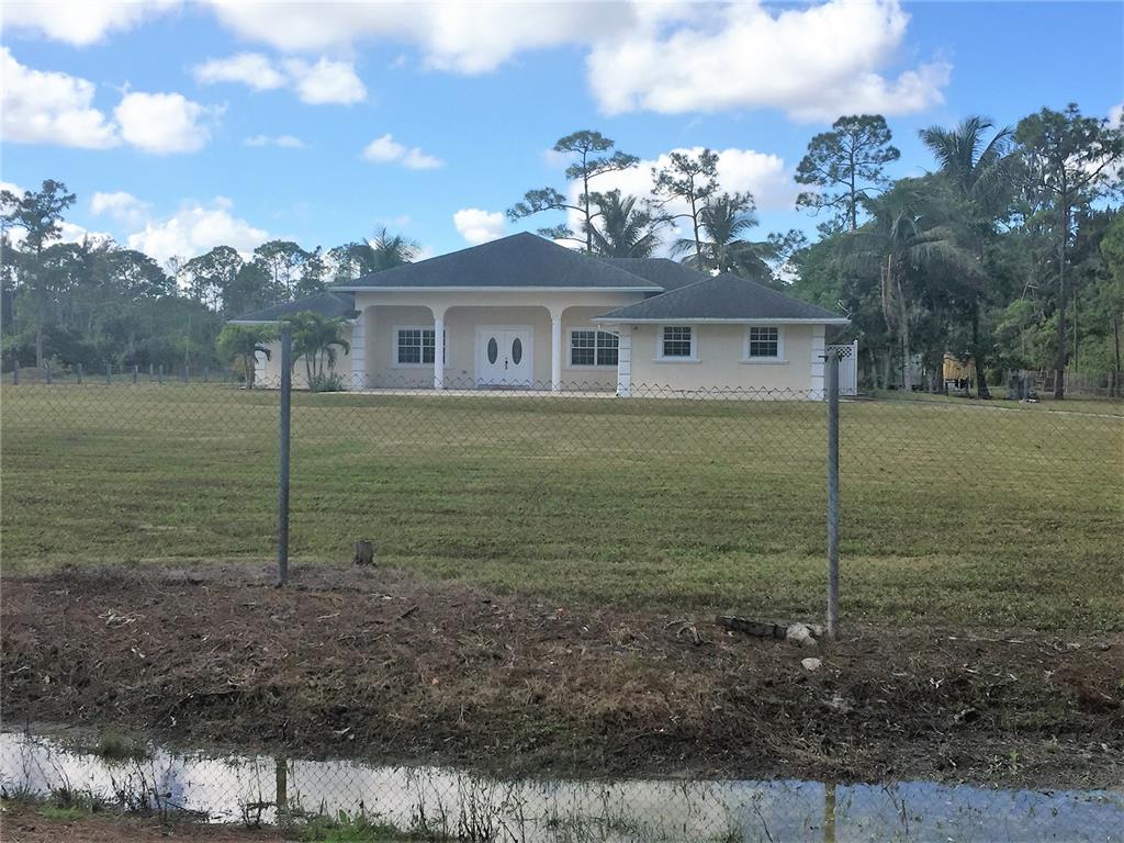 Lots of room to roam and plenty of privacy here on this 5 acres in Loxahatchee Groves! With a beautiful updated 2000+ sq ft home with 4 bedrooms and 3 bathrooms and a split floor plan including a formal dining area and a den, granite counter tops and stainless steel appliances in the kitchen and baths. French Doors lead onto a screened in patio from the main living space and the master bedroom. The patio looks out over the barns and a separate driveway keeps barn traffic away from the main house. Plenty of space for a work and play as well as potentially horses, or other livestock.