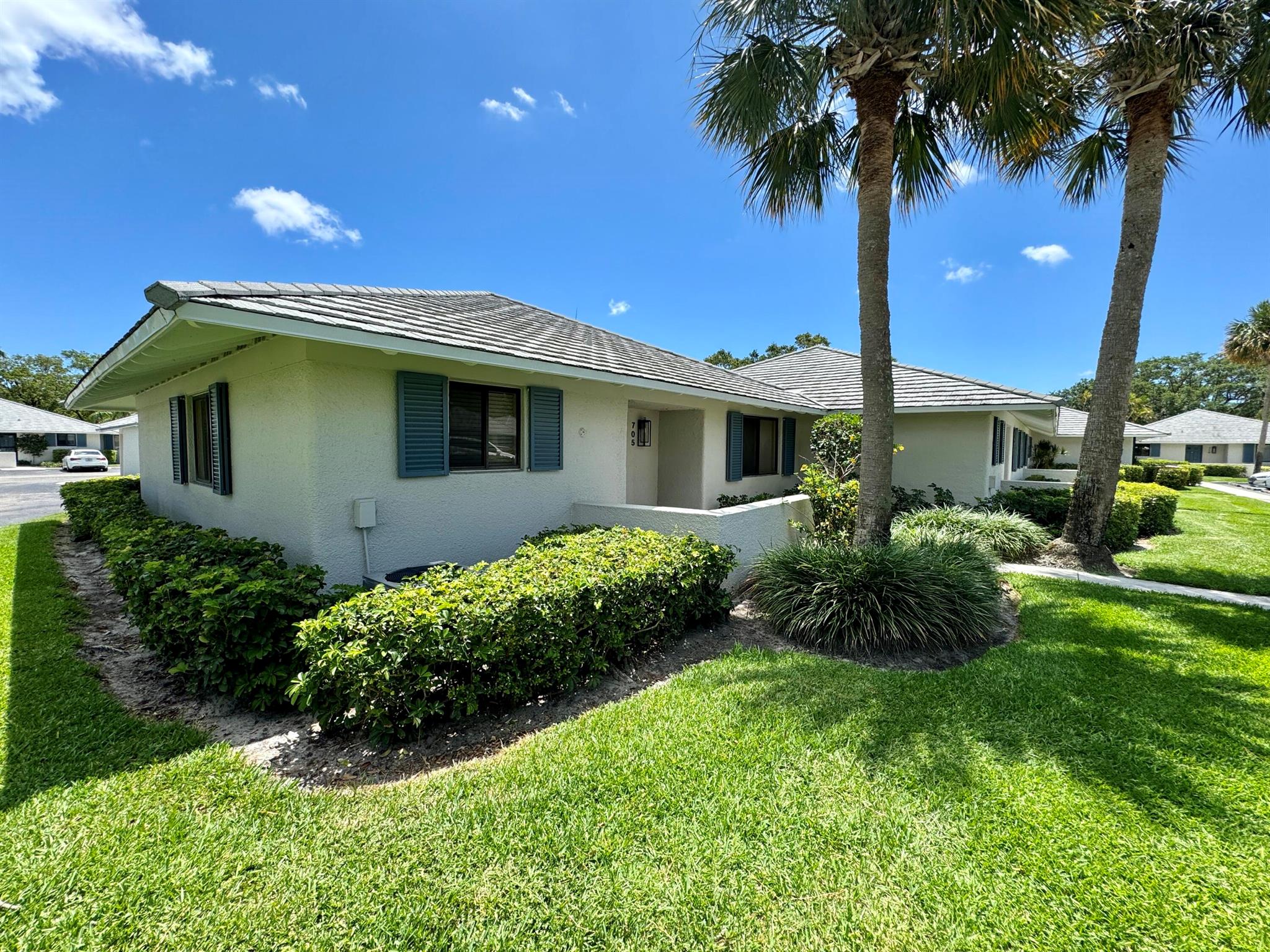 Highly sought-after, bright 2-bedroom, 2-bath end unit, updated with ceramic tile flooring throughout. The kitchen includes granite countertops, a pantry for additional storage, a spacious refrigerator, and a stacked washer and dryer. Bathrooms feature granite vanities.Conveniently located near the Squire Golf Course in PGA National, this unit is within walking distance of the renowned PGA Golf Club, Spa, and Resort. The open main living area features sliding doors that lead to an outdoor patio. Club Cottages provides a beautiful community pool and a picnic area for residents.Enjoy access to all PGA resort amenities. This wonderful, peaceful location offers affordable, resort-like living!