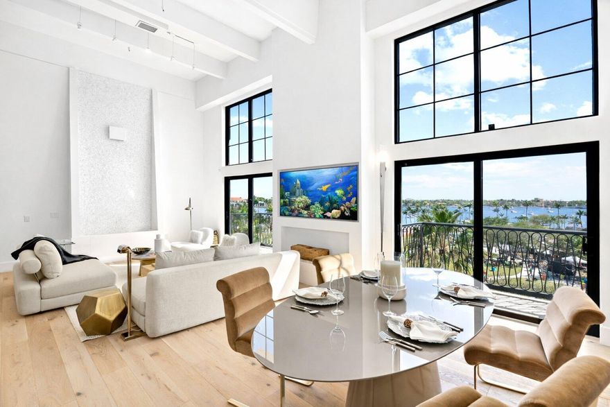 Rare waterfront penthouse-style loft with exceptional architectural volume, located in the only true loft building directly on the water. Soaring 17-foot ceilings & dramatic two-story glass walls frame sweeping Intracoastal & park views, filling the residence with natural light. Designed by Haven Palm Beach, the home features a chef's kitchen with custom oak cabinetry, oversized marble island, high-end appliances, wide-plank European wood floors, spa-like marble baths, and custom closets. A striking 14-foot interior water feature clad in mother-of-pearl tile creates a serene, resort-like ambiance. The building just completed a luxury boutique hotel-inspired full renovation & has low association fees, no assessments, 3 garage parking spaces, pet-friendly living, and 24-hour security.