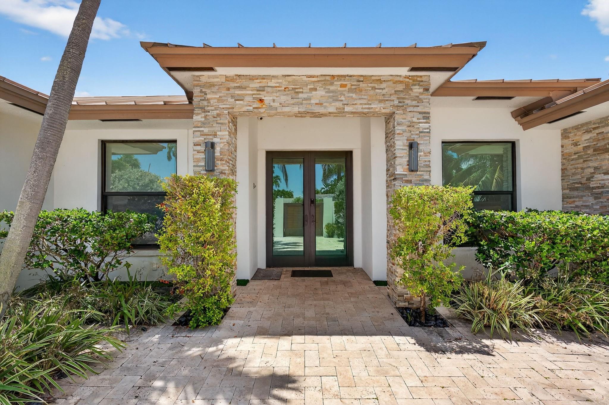 Stunning modern home in prestigious Coral Ridge Country Club! Features 10 ft ceilings, wood plank tile, impact windows/doors, metal roof, and open concept layout perfect for entertaining. Private gated courtyard entry. Chef’s kitchen with quartz island, Viking appliances, induction cooktop, and wine cooler. Living room boasts stone accent wall and wood-burning fireplace. Split floor plan with luxurious master suite offering steam shower, separate tub, and blackout shades. Heated pool with travertine patio, fenced yard, and storage sheds. Just minutes to the beach, shopping, and dining!