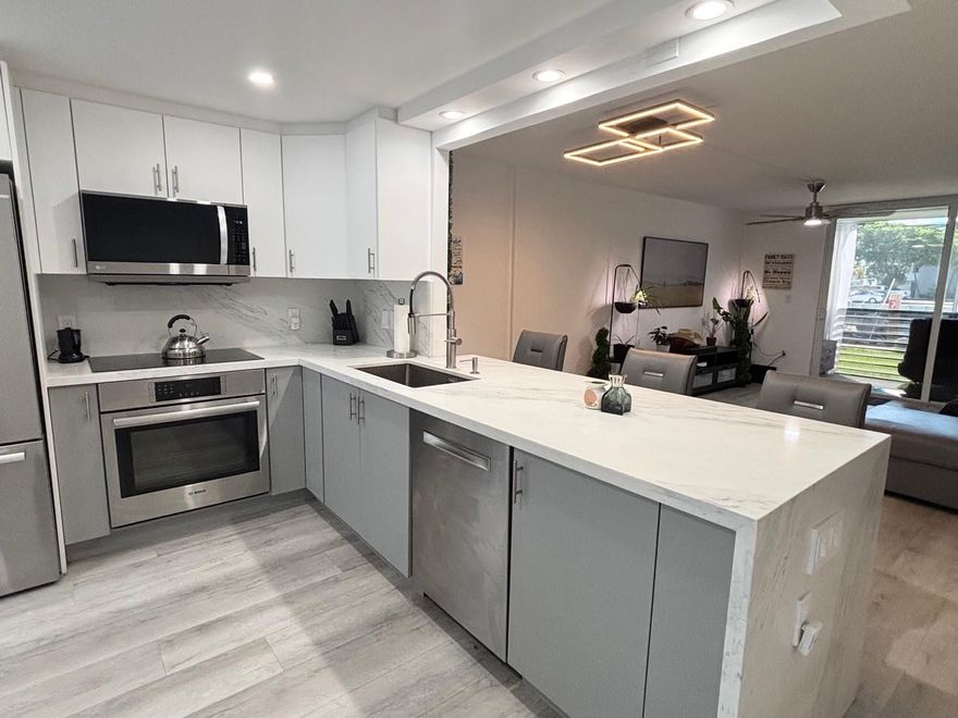 Fully Renovated under permits, Lavish 2Bed 2Bath 1st Floor Condo in 55+ Community. Exceptional upgrades to include Hurricane-impact windows & doors for peace-of-mind and energy efficiency, new kitchen with contemporary cabinetry, Bosch brand stainless steel appliances, and elegant quartz countertops. New laminate flooring seamlessly installed throughout the entire home. Updated bathrooms featuring modern tile, stylish vanities, new fixtures, TOTO brand  bidet toilets, and frameless glass shower enclosures. Dedicated storage room. Step outside your door to enjoy peaceful canal views. Convenient access to community amenities, nearby shopping, dining, and the beaches. Move-in ready — nothing left to do but enjoy! Schedule your showing today and make this waterfront gem your new home!