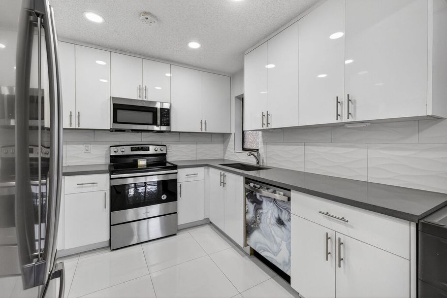 Beautifully updated 3 Bedroom 2 Bathroom condo in Baywood Village I at The Township in Coconut Creek. A new 2025 roof is being installed, and a full 2021 modern remodel, including a sleek kitchen with high-quality cabinetry, quartz countertops, and stainless-steel appliances. Enjoy renovated bathrooms with glass shower doors and contemporary shower panels, elegant 24x24 porcelain tile flooring, new baseboards, LED lighting, custom closets in every bedroom, full-size washer/dryer, 5-year-old water heater, and electrical panel. Accordion shutters throughout. Pets up to 25 lbs allowed. No rentals for first 2 years. Association has reserves. Cable and water included.