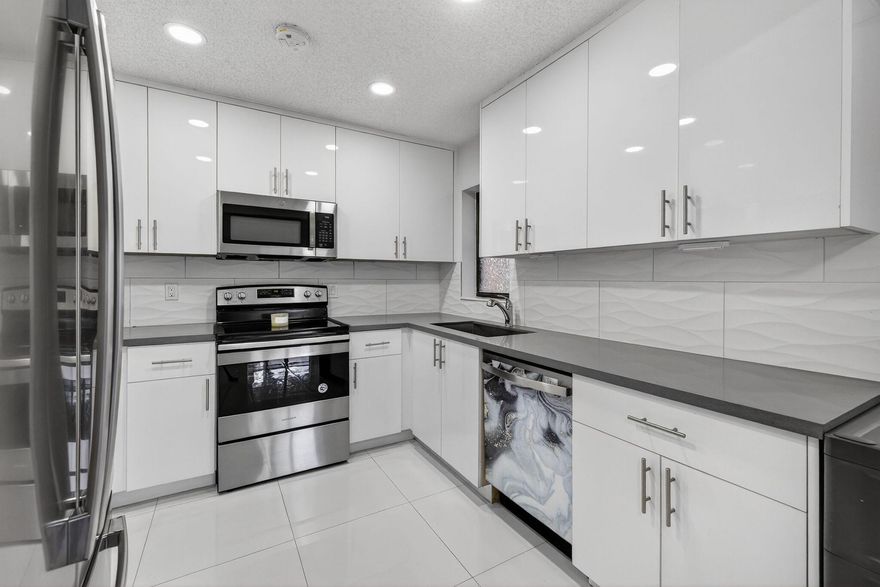 Beautifully updated 3 Bedroom 2 Bathroom condo in Baywood Village I at The Township in Coconut Creek. A new 2025 roof is being installed, and a full 2021 modern remodel, including a sleek kitchen with high-quality cabinetry, quartz countertops, and stainless-steel appliances. Enjoy renovated bathrooms with glass shower doors and contemporary shower panels, elegant 24x24 porcelain tile flooring, new baseboards, LED lighting, custom closets in every bedroom, full-size washer/dryer, 5-year-old water heater, and electrical panel. Accordion shutters throughout. Pets up to 25 lbs allowed. No rentals for first 2 years. Association has reserves. Cable and water included.