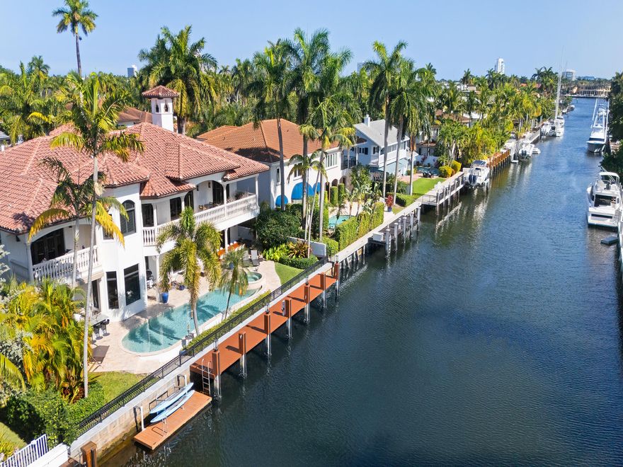 441 Royal Plaza Drive sits on the south side of the Las Olas Isles with 100 feet of deepwater frontage, no fixed bridges, and direct ocean access. One of the few streets on the Isles with private evening security. The backyard is built for South Florida living: pool and spa, covered patio, summer kitchen, and dock on a wide canal. Inside, soaring ceilings, arched passageways, and hardwood floors set the tone. Chef's kitchen anchors the main living areas. Downstairs bedroom and elevator add flexibility. Upstairs, every bedroom opens to balconies with water and skyline views. The primary suite features a study, wet bar, and spa bath with separate vanities, walk-in shower, and soaking tub. 3-car garage, generator, impact windows, superior elevation, Brazilian Cherry and Travertine floors.