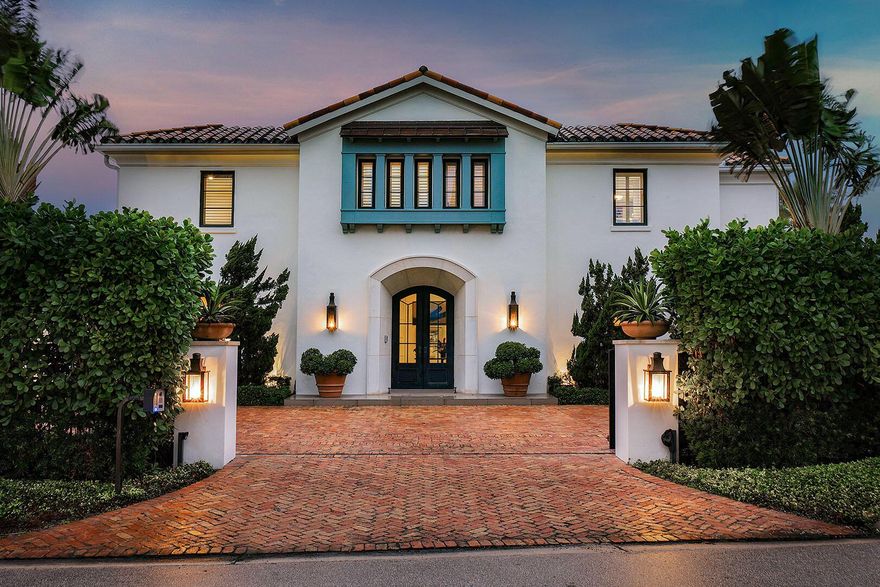 A rare offering on a coveted corner double lot, this Palm Beach-inspired estate blends timeless architectural beauty with modern ease across a sprawling, gated setting. Behind private walls, a brick motor court welcomes you home to five generously appointed bedroom suites, a dedicated office, and a separate first-floor guest wing complete with a yoga room and cabana bath--ideal for hosting with privacy and comfort. The resort-style backyard is a true retreat, designed for year-round enjoyment with a heated pool, lush family-friendly lawn, and a covered loggia featuring a fireplace, built-in BBQ, and wood-fired pizza oven--all enhanced by retractable screens for effortless indoor-outdoor living.