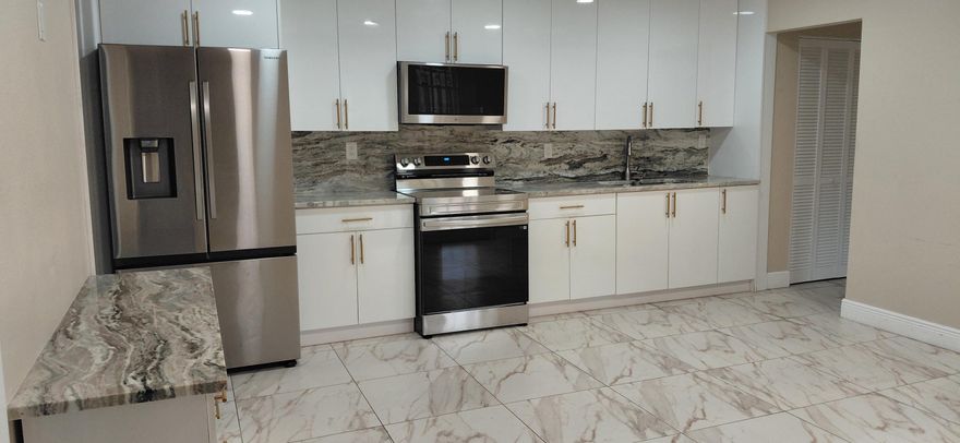 Unique and beautifully remodeled unit featuring brand-new appliances including washer/dryer, A/C, and water heater. Upgraded kitchen with marble countertop, bathrooms, and porcelain tile throughout. Metal roof installed in 2018. The owner thoughtfully reconfigured the layout by converting the original kitchen into additional living space or 3rd bedroom, creating a spacious open-concept kitchen and living area—perfect for growing families. French doors open from the living room, and guest bedrooms, and the master bedroom have a slider that opens up into a partially covered, large courtyard. Move-in ready and a must-see!