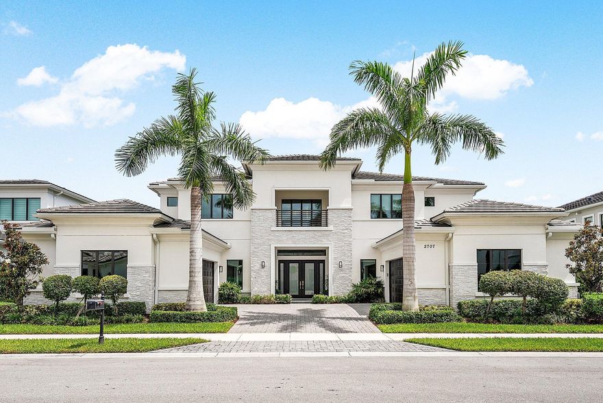 Welcome to 2707 NW 75th Street, a newly built 2022 residence, located in the heart of Boca Raton's exclusive Royal Palm Polo. This stunning home, thoughtfully crafted with high-end finishes and exceptional details, offers the ultimate in luxury living with sophisticated design and well-planned spaces both inside and out. Upon entry, a dramatic double wrought iron staircase sets the stage for the grand interior. Thirty-six-inch porcelain tile floors flow through the main living areas, complemented by custom light fixtures, impact glass, and architectural millwork. The chef's kitchen is a showpiece with leathered quartzite countertops, Wolf appliances, a Sub-Zero refrigerator, built-in coffee machine, pot filler, wine fridge, and a spacious walk-in pantry. The first floor hosts an oversized  primary suite with dual walk-in closets and a large sitting area all with herring bone laid wood floors. The primary bath features a large soaking tub and a double shower. An additional en-suite bedroom, private office, full cabana bath, and powder room complete the level. Upstairs, a loft and another 3 en-suite bedrooms provide flexible living space. Engineered hardwood floors in primary bedroom, office, guest suite and throughout the 2nd floor. Every element of this home has been carefully curated, creating a turnkey living experience where luxury meets comfort. Other features included such as, a 4-car garage with epoxy flooring, three AC units, central vacuum, and a whole-house generator powered by natural gas. Step outside to an expansive fenced yard with no rear neighbor ideal for privacy. Porcelain pavers lead to a covered patio with a wood accent ceiling and electric screens, an outdoor wet bar, and a heated saltwater pool with spa. Residents of Royal Palm Polo enjoy an unparalleled non-membership lifestyle with access to resort-style amenities, including a brand-new Residents' Club with six Har-Tru tennis courts, a state-of-the-art fitness center, resort pool with cabanas, a grand social room, playground, and more.