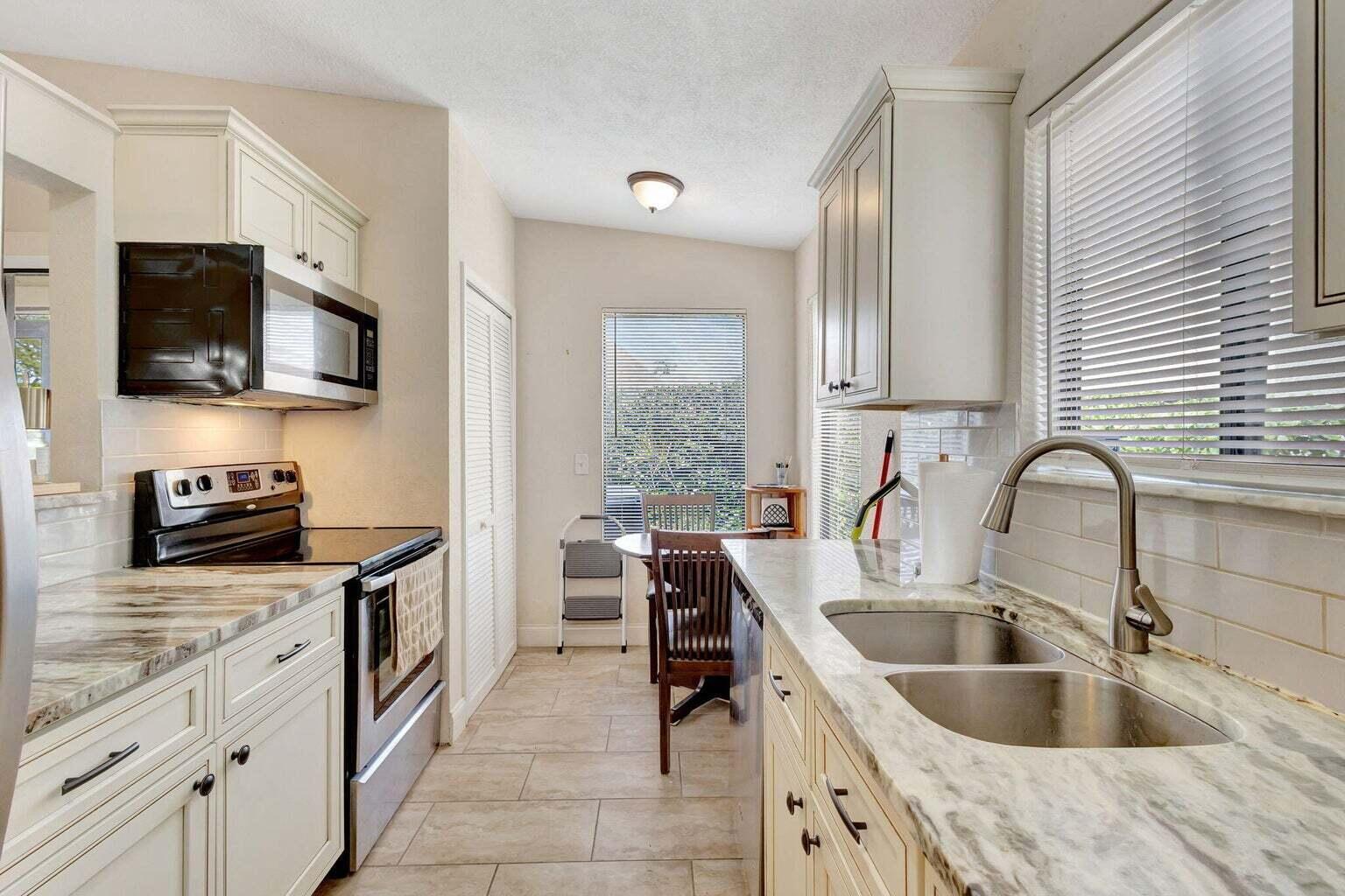 Beautifully updated 2-bedroom, 2-bath villa in the heart of Wellington. This corner unit features vaulted ceilings, wood-look tile flooring, and a modern kitchen with granite countertops and stainless-steel appliances. Enjoy a spacious primary suite with dual vanities and a private covered patio. New roof installed in 2023 and washer/dryer included. Located in Sturbridge Village with community pool access and top-rated schools nearby.