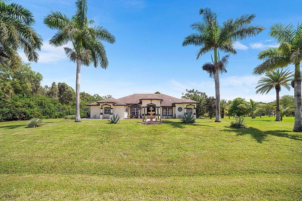 Welcome to this beautifully maintained 3-bedroom, 2.5-bathroom custom home with a versatile den/office, nestled on a spacious 1.14-acre lot in the heart of Loxahatchee. Built and lovingly cared for by the original owners, this property offers privacy, charm, and room to grow.Enjoy the serenity of mature fruit trees throughout the property -- a true Florida oasis. Inside, the home features a split layout, generous natural light, and thoughtful design perfect for both entertaining and everyday living.