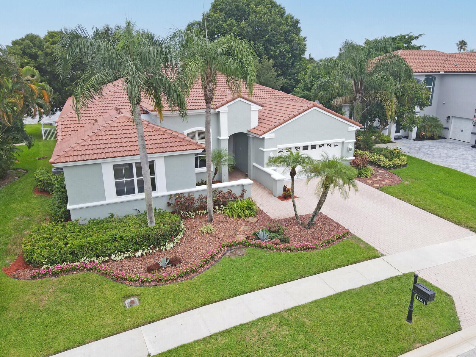 Step into this rare 4-bedroom, 2.5-bathroom home located in the sought after gated community of The Shores at Boca Raton. Situated on one of the best waterfront lots in the community with long lake views, this home offers a rare sense of privacy. Brand new roof installed in 2025! Curb appeal sets the tone with fresh landscaping and a freshly painted exterior inviting you inside to a thoughtfully designed floor plan filled with natural light.Throughout the home, beautiful laminate and tile flooring create a warm, low-maintenance atmosphere. The oversized living room offers 12 foot ceilings and plenty of seating room perfect for soaking in the stunning lake view.