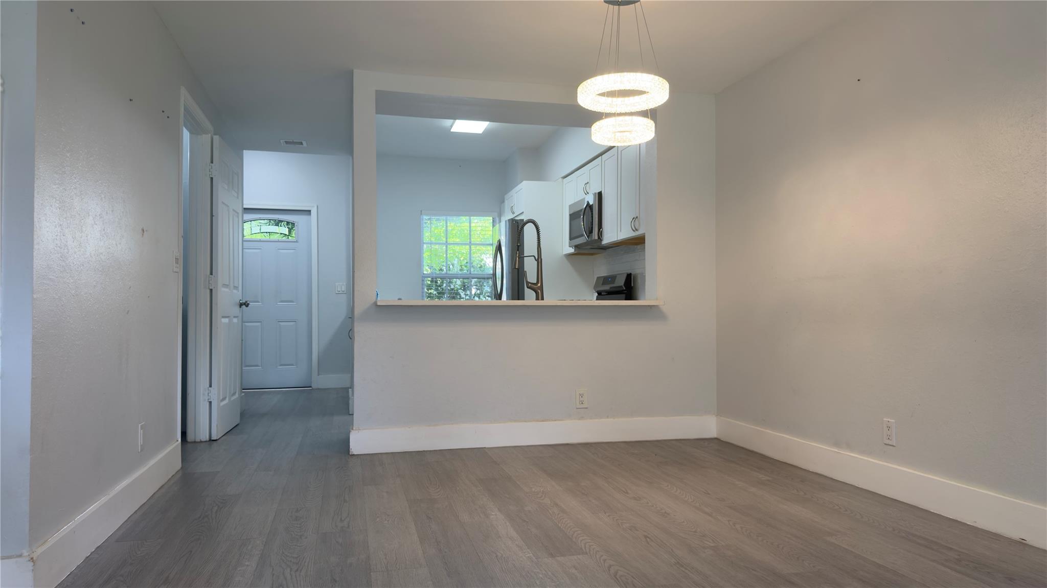 Welcome to this beautifully updated home featuring a modern, open-concept kitchen with shaker cabinets, stainless steel appliances, quartz countertops, and a sleek tile backsplash. The layout offers both functionality and style with luxury vinyl plank flooring throughout, recessed lighting, and updated fixtures. The spacious kitchen flows seamlessly into the main living area, perfect for entertaining or relaxing. This home has been thoughtfully renovated with attention to detail and move-in-ready appeal.