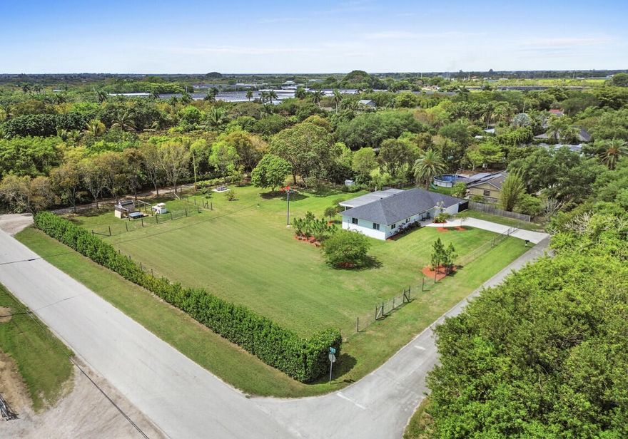 PRIVATE 1-ACRE REDLAND RETREAT! Experience Miami's Country Life in a Gorgeous 3BR/2BA Home. Sale includes adjacent folios/lots = flexibility/potential (buyer to verify zoning/uses). Paved-Road Access on 3-sides of the property provides excellent convenience and accessibility! Home renovated in 2022: New Roof, Impact Windows, Kitchen & Bathrooms, New Flooring throughout. Huge covered/screened Lanai AND large open-air patio. Cozy fire pit. Mature fruit trees. Fully fenced & DOGWATCH. Designated Boat/RV Pad.