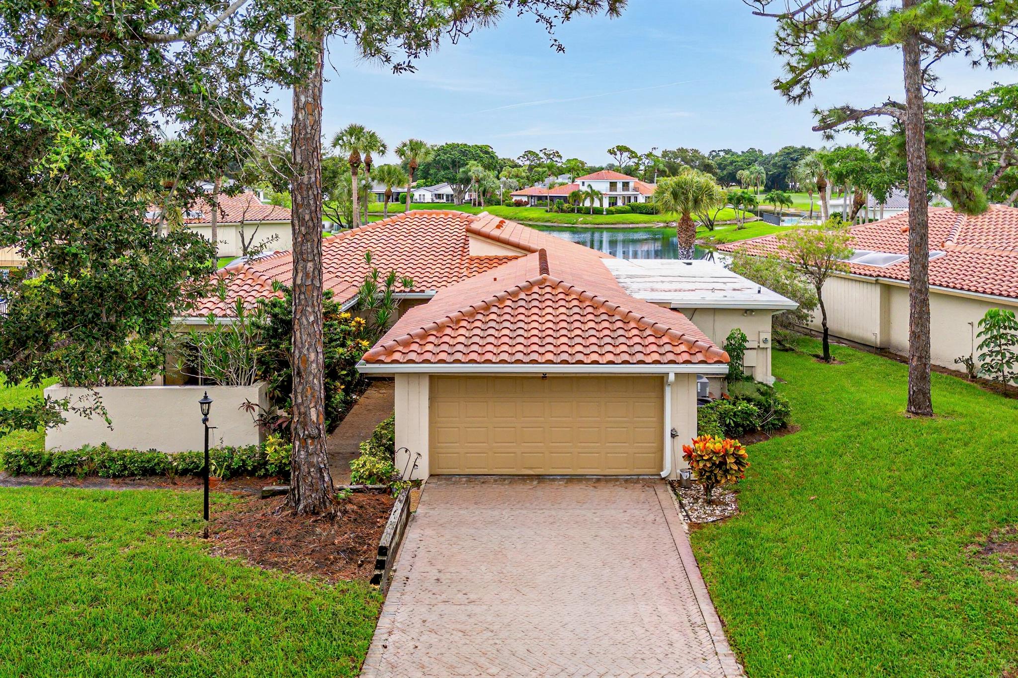 This premium water view residence offers 2,660 sq ft of living space and is steps away from the community pool. This spacious single-level home features 3 bedrooms and 3 full baths plus a powder room. The open-concept great room boasts panoramic long lake views, vaulted ceiling and a wet-bar, perfect for entertaining. The updated kitchen flows seamlessly into the dining and living spaces, complete with stainless steel appliances, custom cabinetry and upgraded countertops. The expansive primary suite offers outfitted walk in closets, and en-suite bath. 2 additional bedrooms and full bathrooms offer accommodations for your guests. Exterior highlights include a Florida room with impact rated windows, two car garage with epoxy flooring, and a screened porch configured for an in-ground spa.