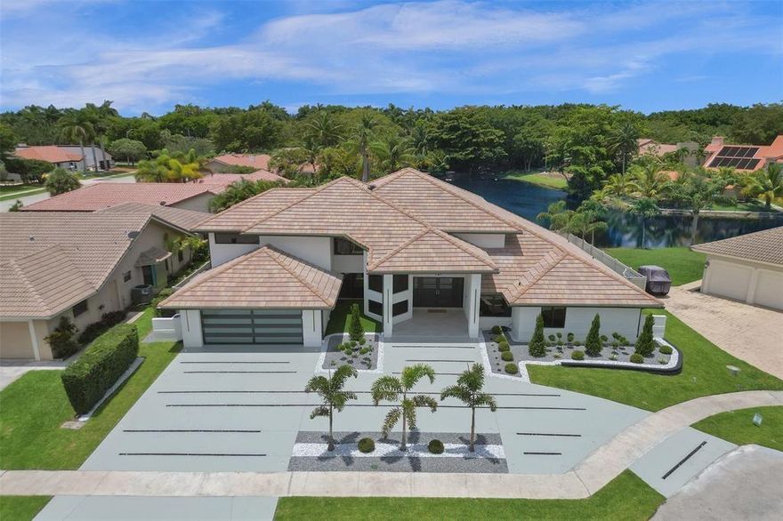Luxury living! Completely renovated 2024! In the heart of Plantation, this stunning property offers unparalleled elegance. 4 spacious bedrooms, each features its own bathroom, Gourmet kitchen with top-of-the-line appliances, custom island & double ovens & double fridge, bar, and plenty of natural light! 2 incredible pools: Lap pool and over sized pool with a Sun deck and outdoor kitchen. This property overlooks the lake with access. 3 New A/Cs!! Impact windows and doors!! Glass encased staircase leads to upstairs sitting area & hidden door leads to master. Master bath includes custom shower and roman tub. Huge Master Walk-in closet! Separate oversized laundry room. Full A/C garage w/tile floors. Every detail of this home crafted to provide the ultimate comfort and style!