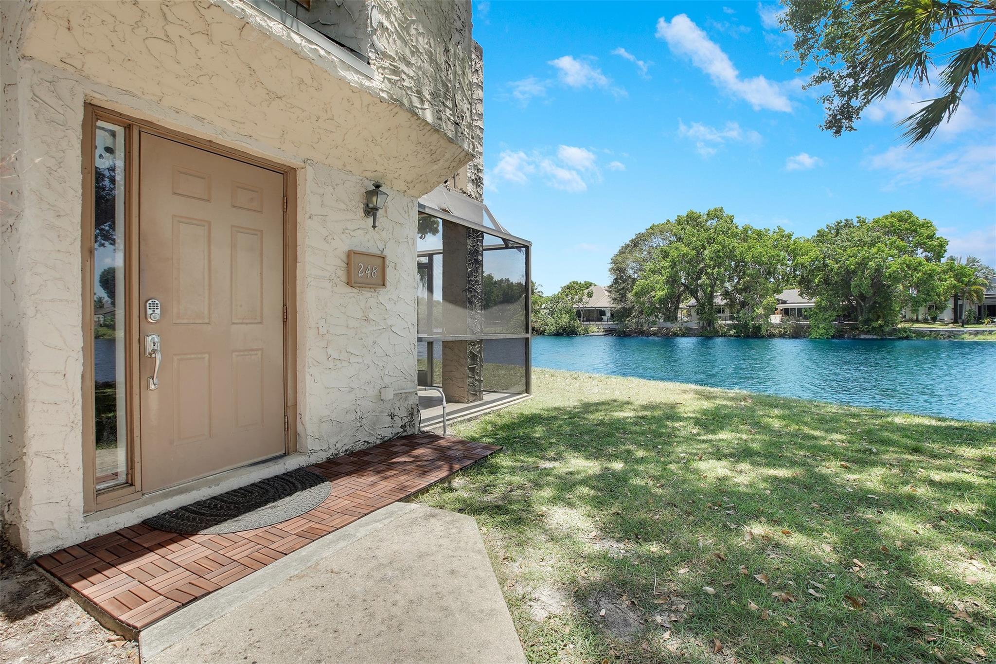 Welcome to your lakeside retreat in the heart of Plantation! This charming 2BR/1BA corner unit offers gorgeous lake views from the balcony, perfect for sipping coffee or winding down at sunset. Step inside from the ground-floor entry and head upstairs to a beautifully maintained space featuring a renovated kitchen, full-size washer/dryer, and a brand-new roof (2024) with assessments fully paid. Water included! Pet-friendly and perfectly located near Central Park, shopping, dining, and major highways. The community features a pool, clubhouse, tennis courts, and exterior upgrades in progress. This is easy, breezy South Florida living at its best!