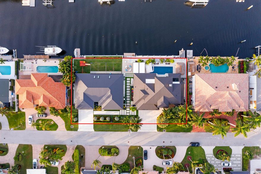 A rare waterfront compound offering two designer-renovated homes with 180' of deepwater in Tropic Isle. 945 Iris features 5BR/5BA, a first-floor primary suite, VIP guest suite, steam cabana bath, two-story living room, chef's kitchen with StruXure pergola, 2019 metal roof, and a 2024 resort pool/spa with Aqualink/Jandy/O2 plus 60' dock. 941 Iris offers 3BR/2.5BA + den, 2023 renovations, skylit patio, designer wet bar, billiard/dining room, epoxy 2-car garage, playground, golf-course turf, and its own 60' floating dock. A shared courtyard with green walls, a cold plunge, and a sand bar completes this turnkey luxury estate.