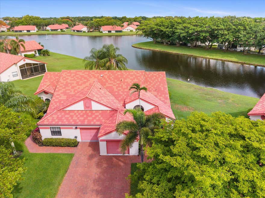 EXQUISITE WATERFRONT VILLA | FULLY REMODELED | IMPACT GLASS | NEW AC 2026 | NO UPCOMING ASSESSMENTS | Discover sophisticated living in the highly coveted Lexington Club. This immaculate residence with soaring cathedral ceilings and refined engineered hardwood floors frames a bright, open floor plan illuminated by LED accent lighting and tailored with custom electric shades. The gourmet eat-in kitchen features premium quartz countertops, custom cabinetry, and stainless-steel appliances. Seamlessly transition outdoors to a serene, covered and screened patio overlooking pristine water views. Enjoy a resort-caliber clubhouse, heated pool/spa, fitness center, and tennis/pickleball. All just minutes from pristine beaches and downtown Atlantic Avenue. | Roof 2016 | AC 2026 | WH 2022