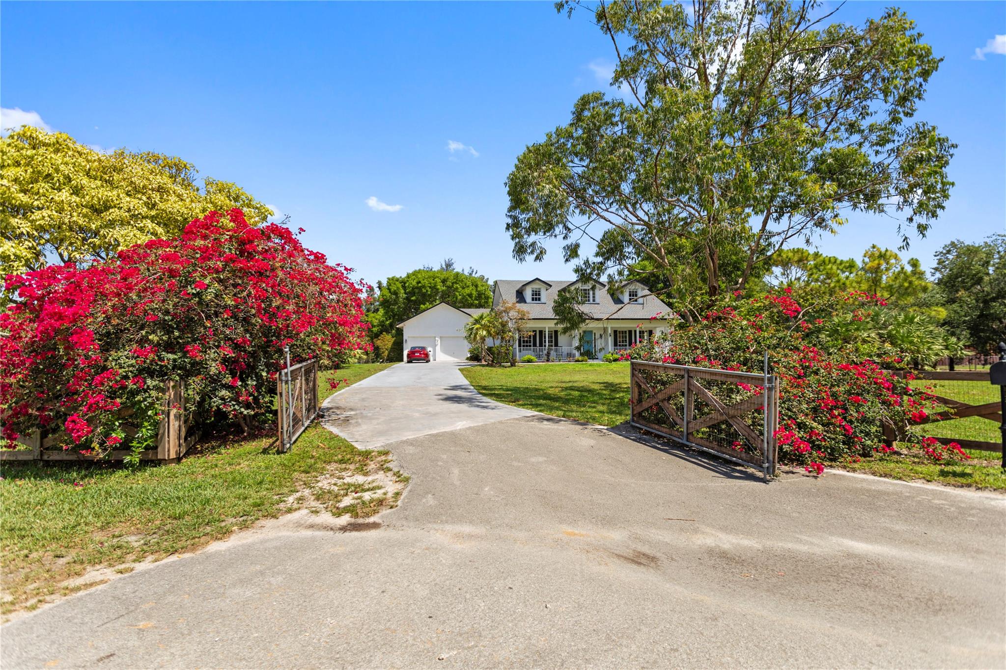This impeccable custom built 2 story, 4 Bedroom, 4 Bath home on over 2 1/2 acres is truly a rare find! From the second you arrive at the picturesque entrance to the exquisite veranda entrance to this home (perfect for morning coffee) you will feel the tranquility. This home truly has it all...Huge primary on first floor with French doors & 2-sided fireplace, two rooms upstairs with private bath for each, fourth room downstairs with French doors currently being used for office, "two" 3.5 Ton a/c units, new roof 2025, a chef's kitchen with gas stove and beautiful appliances, fireplace, family room large enough for friends & family. Plenty of parking for vehicles & trailers, mango trees & a mulberry tree. Enormous backyard area with pool for huge parties, which was redone 2025 & SO MUCH MORE!