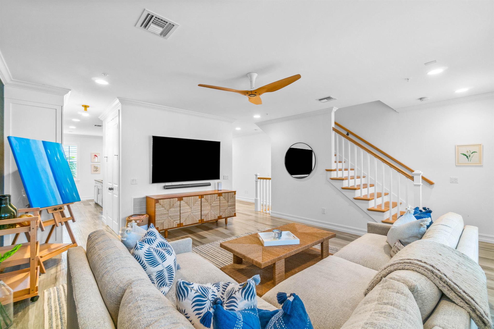 Located in the heart of Pineapple Grove Village, this beautifully upgraded townhouse sits on the most desirable side of Cannery Row (West), offering refined living in one of downtown Delray Beach's most attractive communities. The first floor includes a spacious two-car garage and a private en-suite bedroom with a bathtub ideal for guests or as a quiet home office, separated from the main living areas. A staircase with solid hardwood treads and risers leads to the second floor, where you'll find matching wood floors and a thoughtfully designed layout. The large eat-in kitchen features white Shaker-style cabinetry, light granite countertops, and an oversized island that functions as both a practical workspace and a central gathering spot.