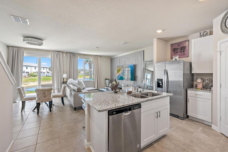 Welcome to 5646 Enclave Drive, a contemporary 3-bedroom, 2.5-bathroom townhouse nestled in the gated community of Enclave at Mangonia Park in West Palm Beach. Built in 2023, this 1,485-square-foot residence offers modern living with energy-efficient features. Interior features include a modern kitchen equipped with 42-inch white shaker-style cabinets, beautiful granite countertops, and light gray tile flooring, creating a sleek and inviting space. Spacious living areas: the open floor plan seamlessly connects the kitchen to the living and dining areas, ideal for entertaining. Flexible loft space: A versatile open loft on the second floor can serve as a home office, media room, or play area. Convenient laundry: A walk-in laundry room located on the