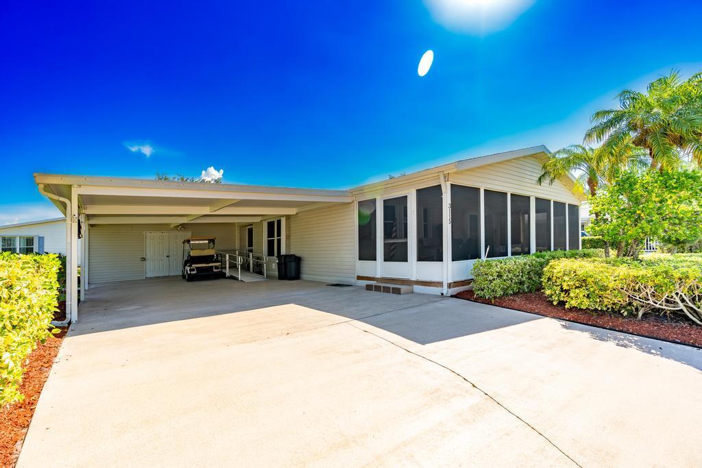 Lovely home in the sought-after Savanna Club 55+ community, featuring a 2-car driveway and covered carport. This 2-bedroom home with a den/office offers plenty of space and comfort. Enjoy newer laminate flooring (2022), plantation shutters, and drywall (no paneling) throughout. The open kitchen provides ample cabinet and storage space, perfect for everyday living or entertaining. Vaulted ceilings, tubular skylights, and a large covered/screened front patio create a bright, welcoming atmosphere. The primary suite includes a walk-in closet, dual sinks, and a newly renovated walk-in shower. Additional upgrades include accordion hurricane shutters, 2023 appliances, and ADA wheelchair accessibility. 2017 roof. A/C age unknown. (Move-in ready and full of charm!
