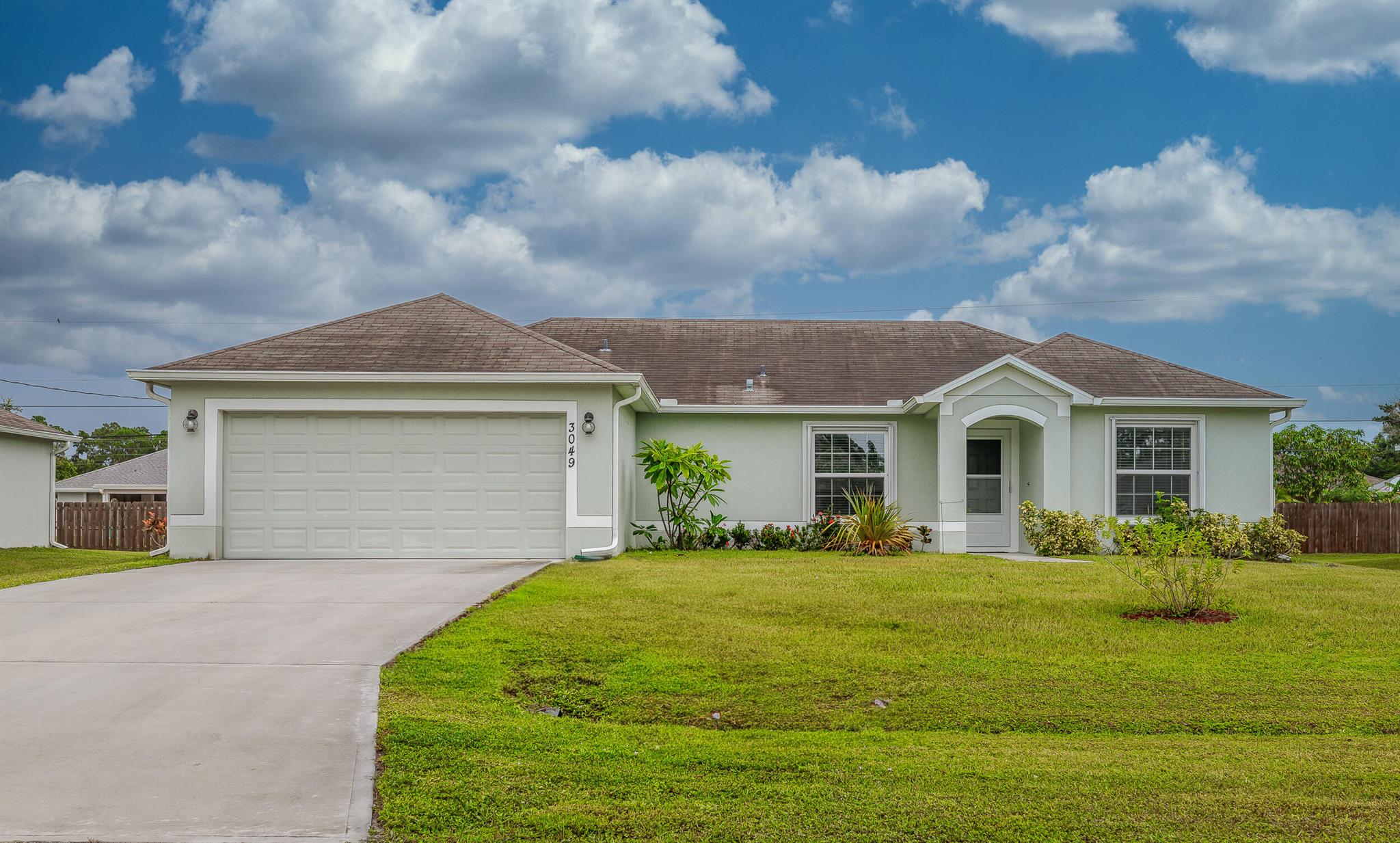 Welcome to this bright and beautifully maintained 3-bedroom, 2-bath home with a 2-car garage, built in 2019 and perfectly situated in the heart of Port St. Lucie. This spacious home offers a large open floor plan filled with natural light, creating an inviting and comfortable living space. The kitchen features a center island with a sink that also functions as a breakfast bar, ideal for casual meals or entertaining guests. The generously sized master suite includes dual sinks, a walk-in closet, and a shower/tub combo for added convenience. The split floor plan offers privacy with two additional bedrooms and a second full bath. Step outside to enjoy the huge backyard, perfect for gatherings, pets, or future additions and a screened-in patio for relaxing year-round. This home has it all!