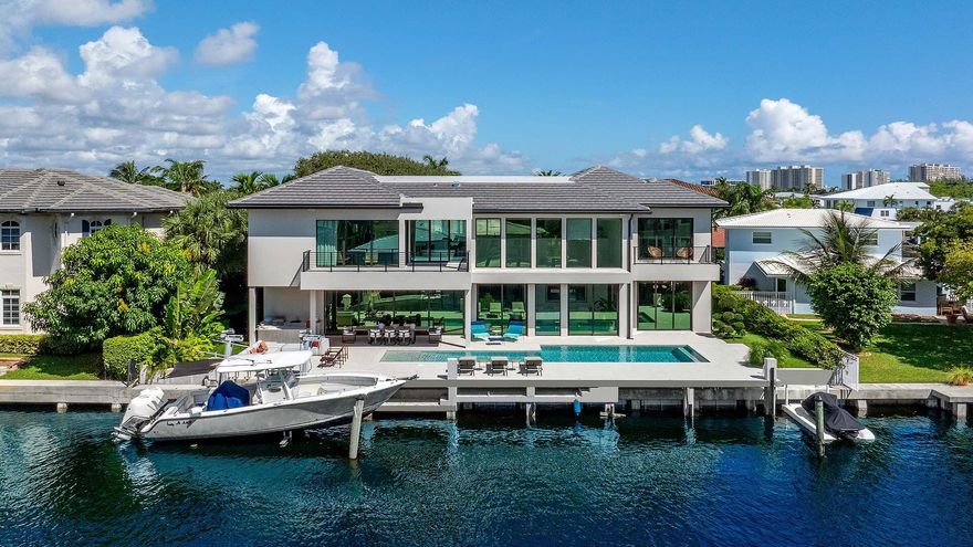 Like-new modern waterfront estate in the coveted Lake Rogers community of East Boca Raton. Built in 2024 by Elysee Homes, this exceptional residence offers 90 feet on the water with direct Intracoastal views. Elegant herringbone wood floors, designer lighting, and a sleek chef's kitchen with Wolf gas range and integrated appliances define the interiors. Expansive pocket sliding glass doors create seamless indoor-outdoor living with pool and entertaining areas. Includes a first-floor guest suite and club room plus a stunning primary suite with dual custom closets, spa-inspired bath, and panoramic water views. Moments from the beach and close to Downtown Boca, Delray, international and private airports. A rare opportunity and property offering a lifestyle second to none.