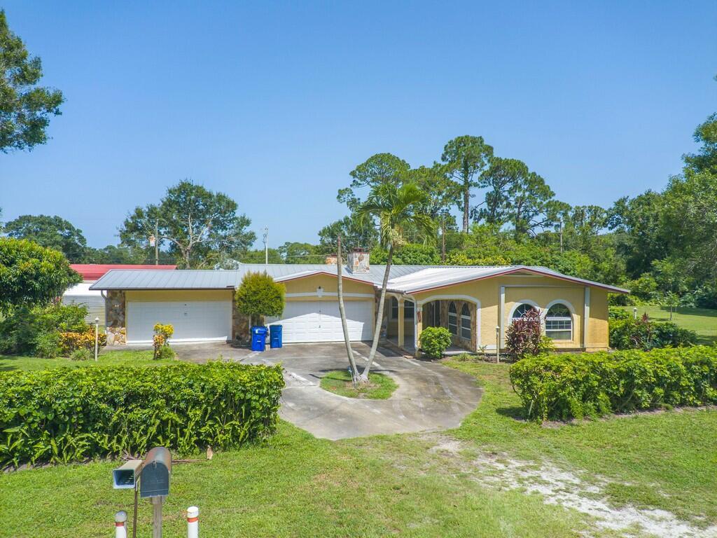 This Huge 1 acre corner lot is a fully equipped compound ready for abundant living, privacy and accessibility. Accompanied by a 2,482 sqft CBS home with 4car garage, huge storage shed + camper shed. Mature fruit trees align the parameter of a manicured lot with plenty parking for All toys boats/Rvs/Trucks etc. Home feats 4 beds 3.5 bath, New metal roof, New generator, 2 New a.c, 2 wood fireplace, plantation/accordion shutter, surround sound plus formal bar-living-family-dining-b-nook-den-exercsie-sun room. Optional living areas with 2 en suites. Short drive to local beaches, shopping and more!