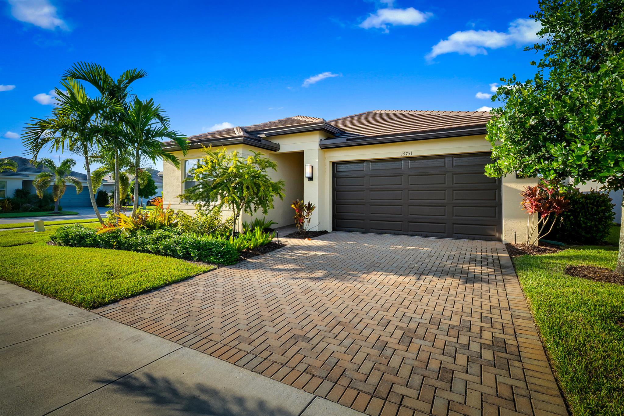 Step into this Sandpiper model with 1,760 living space under air, 2 bedrooms + office/3rd bedroom with pocket doors, and 2 baths. Corner lot with added Clusias for full privacy with fencing and screened patio. Upgrades include diagonal tile, recessed lighting throughout, impact windows, marble windowsills, full gutters, and extra TV hookups inside and on patio. Kitchen with pantry, finished back panel of island with added GFI. Primary suite features 2 walk-in closets, dual sinks, tiled-to-ceiling shower. Guest bath also tiled to ceiling. Laundry room with sink. Valencia Grove offers world-class 55+ amenities: clubhouse, resort pool with cabanas, fitness, pickleball, tennis, and endless social events. Move-in ready with security system.