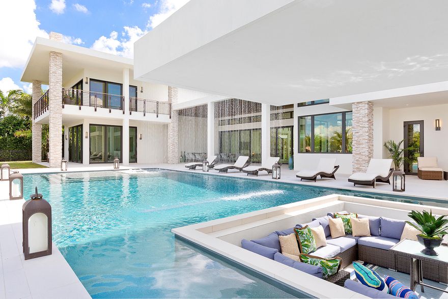 Live and entertain like a Rock Star in the newest and most sought-after community in Wellington's Palm Beach Polo Club.  The  exquisitely constructed, gated, 6-bedroom/8.5-bath lake-view transitional home was designed by Insite Design Group.  Boasting a double master suite on both floors, outdoor shower, two double garages with pull-through design and a staff / in-law quarters with private entrance. Enjoy sunset water views behind the cascading waterfall from the comfort of the sunken lounge. Unprecedented and extraordinary swimmers dream pool & spa, terrace,  entertainment area and summer kitchen.