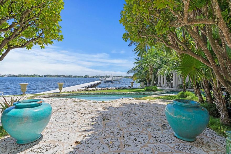 Available March 1, 2026 - Located directly on the intracoastal, this single-story home is a perfect seasonal rental for someone searching for a tropical island feel, expansive water views yet quick access to Palm Beach Island. The home has an open floor plan, light filled rooms, high ceilings and abundant windows and glass doors. The home also offers Asian influences with building details and decor. Features include: a large gourmet kitchen (fully stocked), a greenhouse & herb garden, charming outdoor shower, orchid garden, full landscape lighting, a large two-car garage with extra storage, a built in grill, security lighting & gates and a 1,000 sq. ft. private dock area looking out at ''Billionaires Row'' estates on Palm Beach.