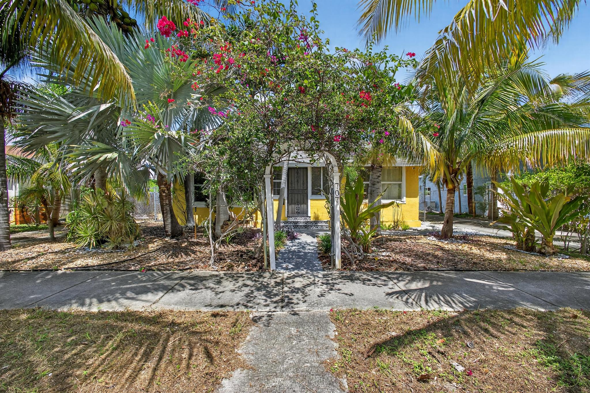 This charming home is a 3bed/3bath with numerous updates including impact windows, restored wood floors, all new kitchen, lighting, new bathrooms plus much more. Tropical landscape leads you into a cozy front porch, then a welcoming foyer, on to the spacious living room that boasts a beautiful fireplace and archway into the dining area with bay windows, then on to the gourmet kitchen and a huge utility room. The main bedroom is on the 1st floor with an en-suite bathroom, bedroom 2 is also an en-suite and has a private entrance, perfect for an in-law suite or income studio, bedroom 3 is upstairs with a huge walk-in closet. The yard is an outdoor oasis with multiple lounging areas, paver patios, artificial turf and fully fenced with lots of parking. Close to beaches and PBI airport. Hurry!