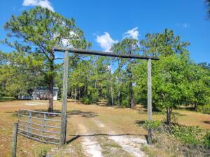 Country living!!! Gorgeous 5+- wooded acres with a 2/2 DWMH. This property is very serene and private with large oaks and pine trees surrounding the home. The property is fenced all the way around with a ranch style entrance and gate. Home has a new roof but needs some Tlc. Plenty of room to add a barn and have all your toys and animals.