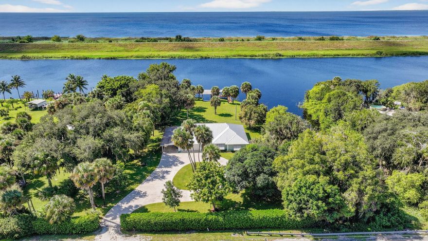 What we have here is a unicorn location!  Situated on 1.214 acres of private land with over 450' of waterfrontage that stretches across the back and along one side of the lot.  These listings don't come up for sale very often, so don't delay in checking out this solidly built 2221 SF CBS home.  Whether you're into boating, fishing, kayaking, or just enjoying nature at your fingertips, this is a prime spot for it all!  Backed up to the Rim Ditch/C-24 canal and right next to the Locks to bring you into Lake Okeechobee, we've got the best spot in town. Enter the fenced and gated yard and you can immediately appreciate the yard space.  You'll have parking for everyone on the long driveway with circular extension.  There is a covered carport for protecting your toys, as well as a 2-car garage,