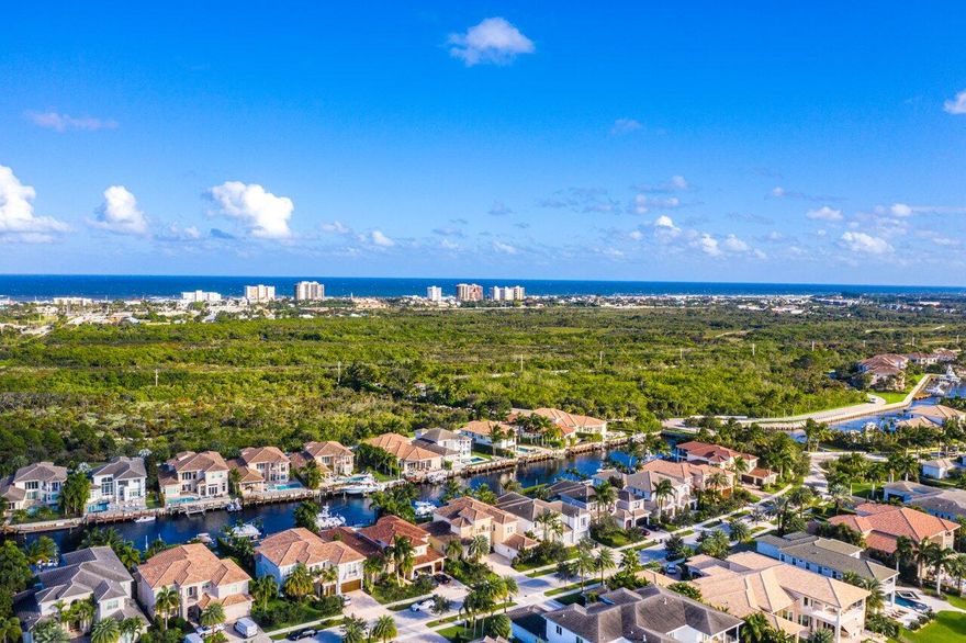 Stunning 6BR estate. Exterior tastefully updated w/stone accents, new paint in/out, new fixtures/fans, 70' waterfront, minutes to Intracoastal, no fixed bridges. Gracious 2 story entry, floor to ceiling natural light. impact glass throughout, gourmet kitchen w/SubZero & Wolf appliances, beautiful wood floors in main living areas, downstairs master suite w/bay window, custom built-in bench, spacious master bath, 2 large walk-in closets. Custom office, downstairs guest suite. Spacious upstairs living area, 4 additional guest suites, storage room. Backyard oasis w/Easterly exposure, private pool, summer kitchen, artificial turf, dock w/16,000lb lift on deep water, no fixed bridges to ocean, 3 car garage w/epoxy floor, freezer, ice maker. Gated enclave between Palm Beach & Jupiter Inlet ... Additional updates include, Master bathroom plumbing fixtures, all granite tops throughout have been honed and resealed. New outdoor fixtures along with stone work added to summer kitchen, and new wrap around awning.