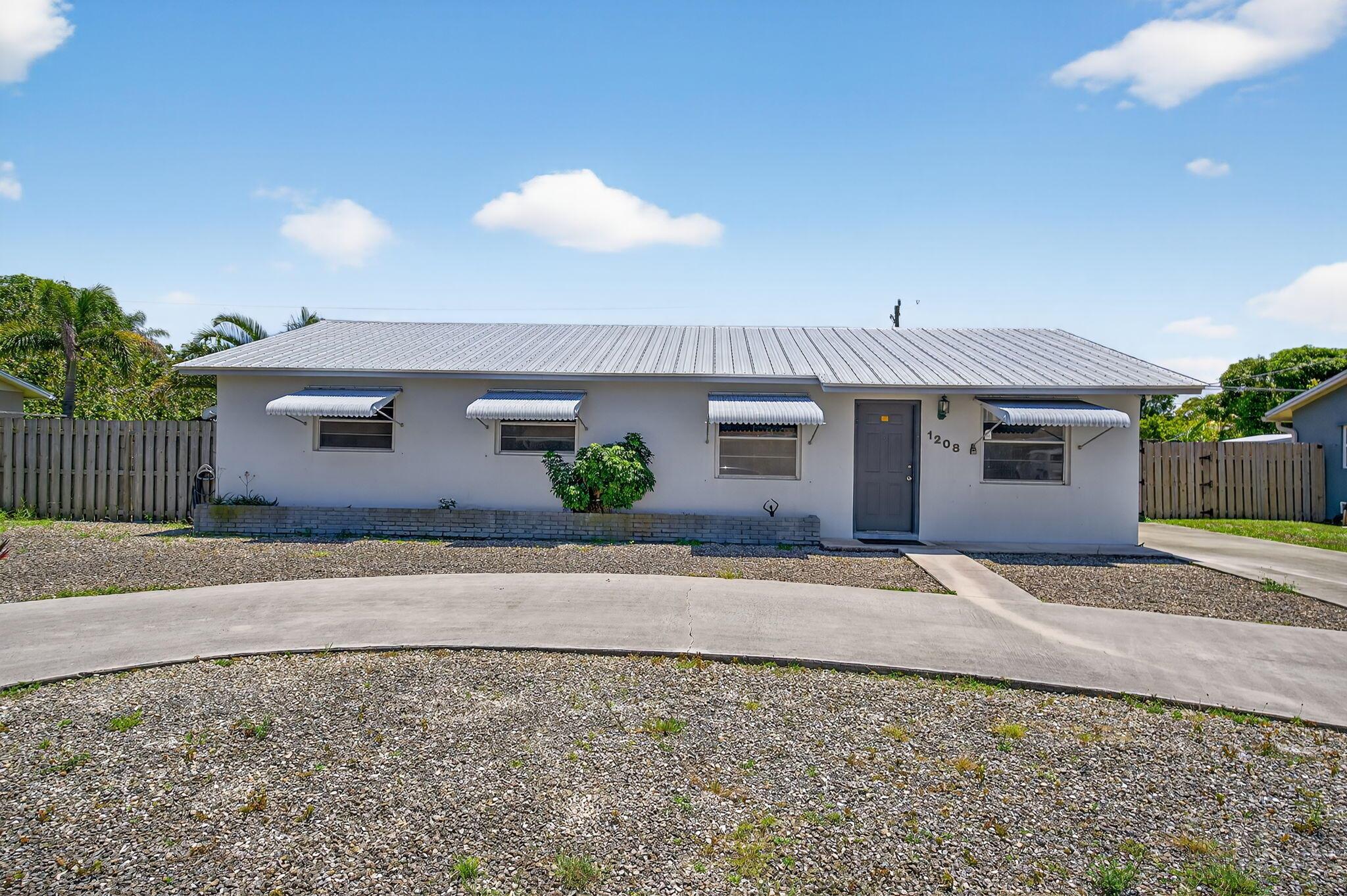 Welcome to Jupiter River Estates! Come see this Charming CBS home with a 2021 METAL ROOF! The Large Beautiful Yard is completely Fenced. Ideal for Hosting Gatherings with Family and Friends. It has a Gorgeous Mango Tree. Get ready to have your very own Mango Smoothies. The Half Circle Driveway provides Multiple Vehicle Parking. There is Plenty of Room to park a Boat or Trailer on the Concrete Slab on the west side of the home. Hurricane Ready with Bahama Shutters. There is Additional Space Off the Kitchen in the Large Florida Room. NO HOA. Easy Access to Publix, Restaurants, Shopping, Beaches, Parks, Roger Dean Stadium, I-95, Turnpike and PBI Airport. Schedule a Viewing Today!