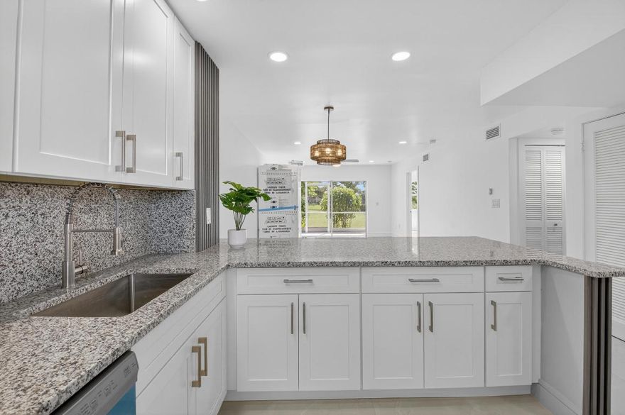 REDUCED!!! Magnificently remodeled 2 bedroom,  2 bath first floor unit overlooking the lake and garden beyond.  55+ Community. Sheer luxury featuring:. New AC  system, New Electrical Panel,  Neutral Porcelain tile throughout along with skimmed ceilings.  Kitchen boasts New stainless steel appliances with   extended granite counter. , impact windows.
Greet guests  in the formal foyer entry.  Enjoy your gourmet white kitchen with granite counters.  Great room with dining area  is perfect for relaxing or entertaining.  Primary bedroom with  walk in closet and lavish primary bath. Guest bedroom and guest bathroom is ideal for friends.     Close to shopping, major roadways and 25 minutes to the beaches.  Florida living at its best.  Great room and primary bedroom has staged photos