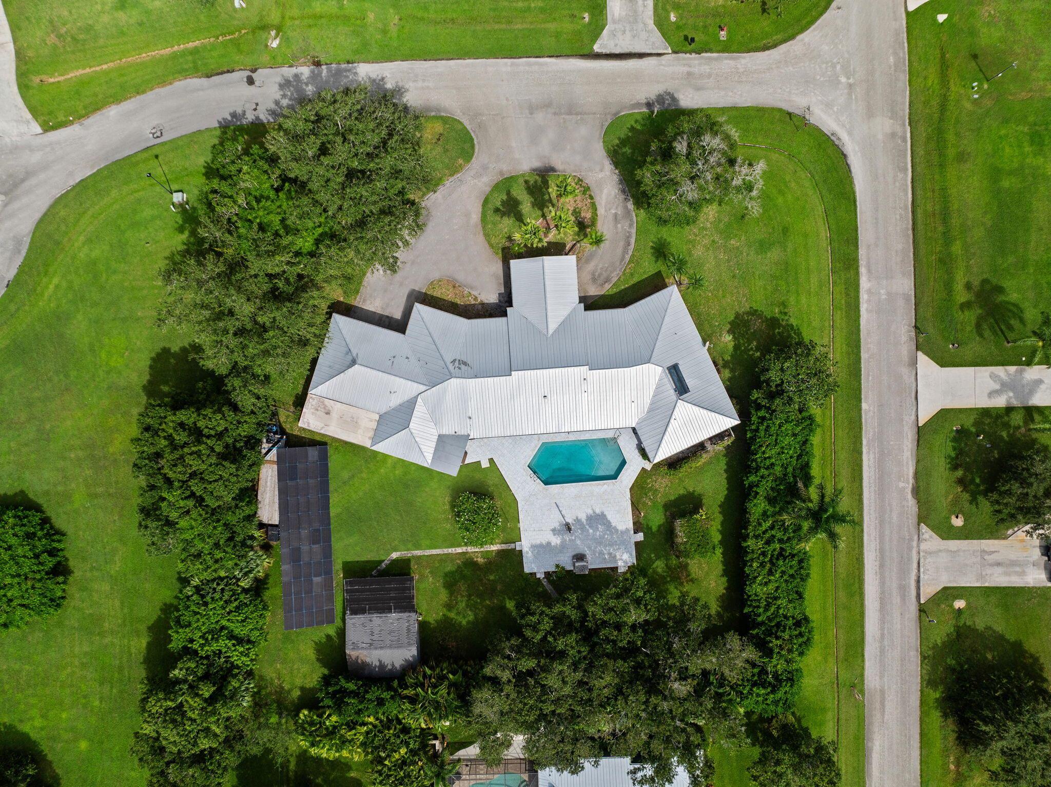 Discover over 4,000 square feet of refined living in this stunning custom estate, perfectly designed with a split floor-plan and timeless upgrades. This home blends modern efficiency with a mid century flare--featuring a metal roof, buried propane tank and paid-off solar panels that power the entire home for sustainable living, with you in control.Entertain in style with your inground pool, expansive yet private .85/acre fenced yard, and a massive marble pool deck complete with a brick outdoor fireplace--the ultimate gathering space. Inside, a dedicated office provides work-from-home convenience, while the chef's kitchen is a true masterpiece: porcelain counters, induction + gas cooktops, Sub-Zero refrigerator, warming drawer, and double oven. You really must see it to appreciate it!