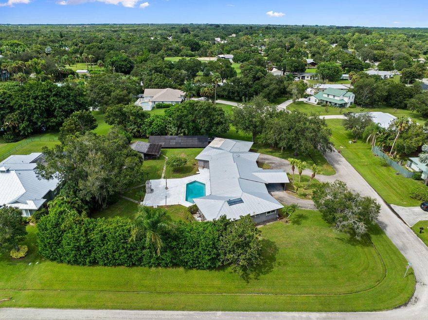 Where can you find a home like this, in a neighborhood like this?! ONLY HERE!Discover over 4,000 square feet of refined living in this stunning custom estate, perfectly designed with a split floor-plan and timeless upgrades. This home blends modern efficiency with a mid century flare--featuring a metal roof, buried propane tank and paid-off solar panels that power the entire home for sustainable living, with you in control.Entertain in style with your inground pool, expansive & private .85/acre fenced yard, and a massive marble pool deck complete with a brick outdoor fireplace, the ultimate gathering space. Plus a dedicated home office, the chef's kitchen is a true masterpiece: porcelain counters, induction + gas cooktops, Sub-Zero refrigerator, warming drawer, and double oven.